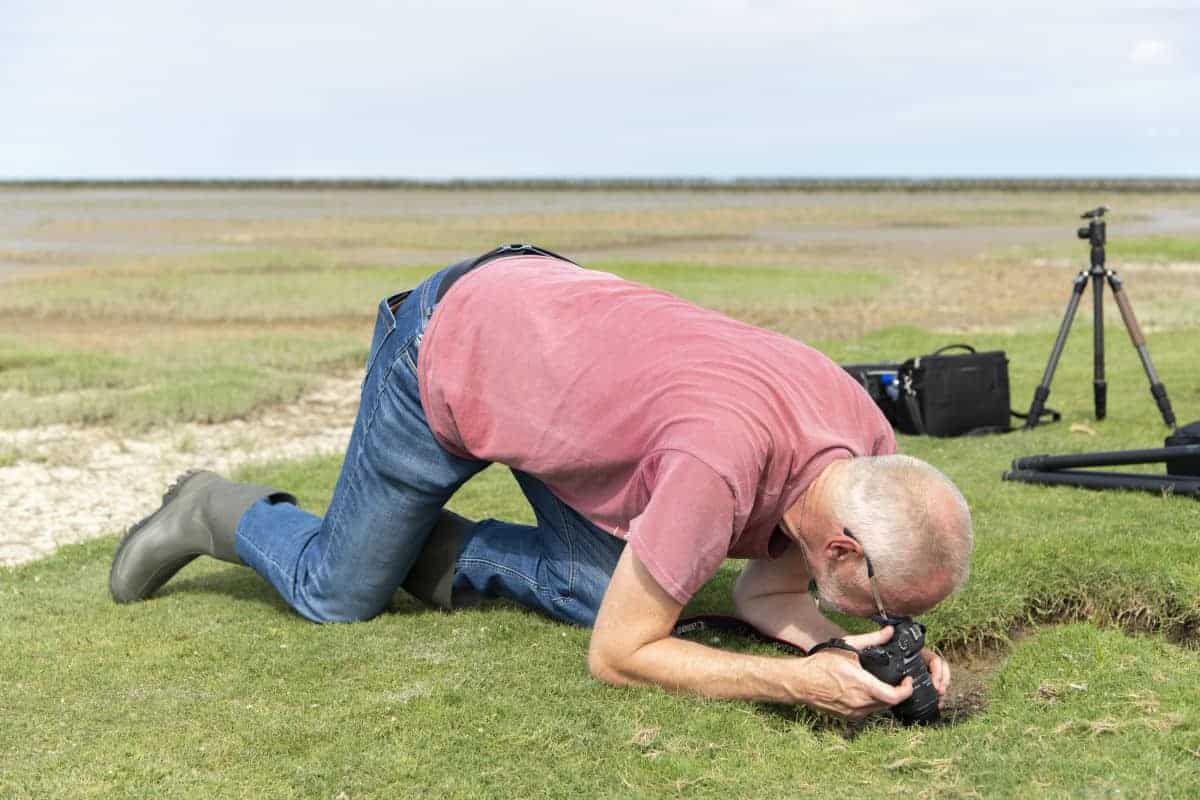 Deelnemer kruipt over de grond tijdens Groninger Waddenkust