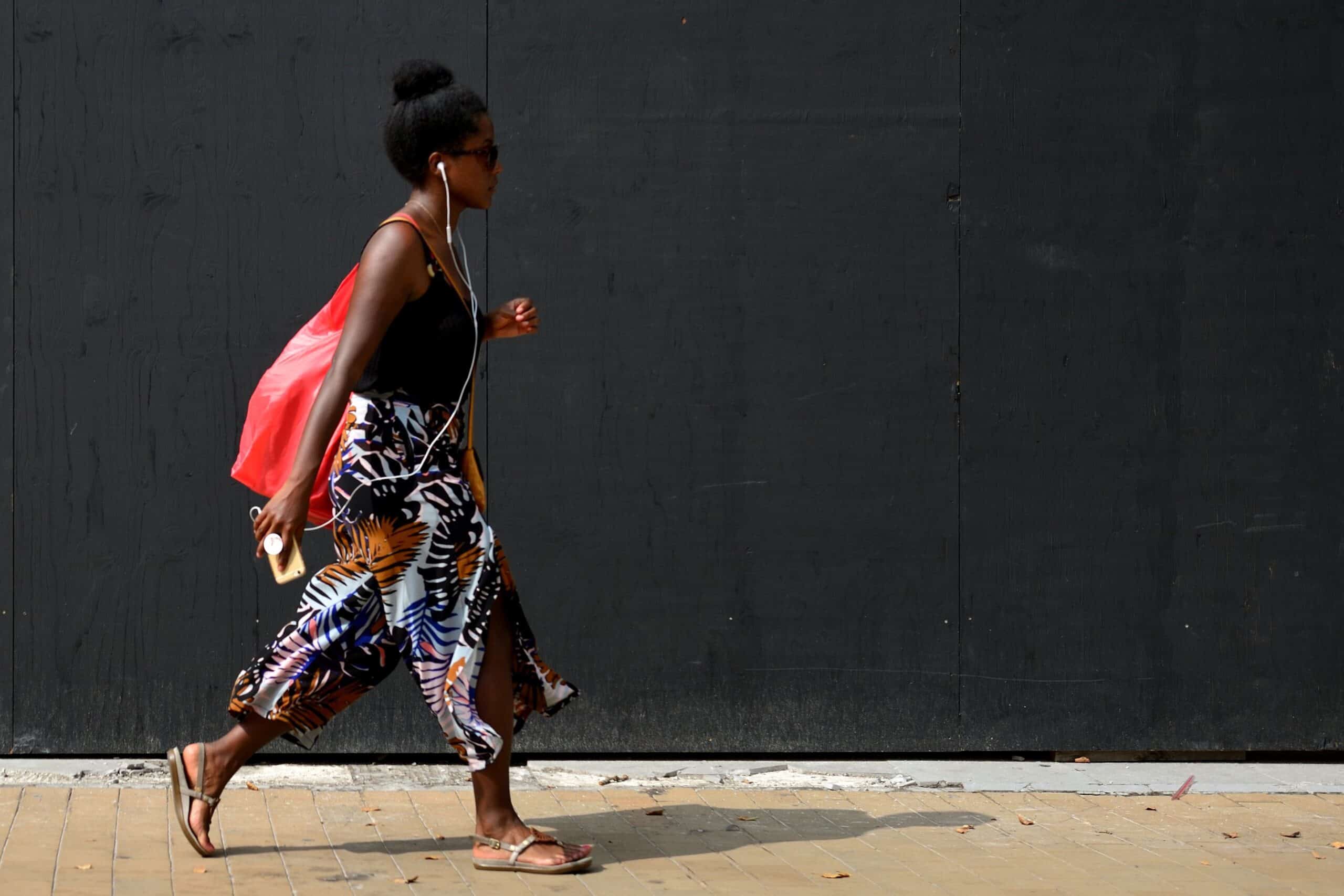 Vrouw loopt voor donkere wand tijdens workshop straatfotografie