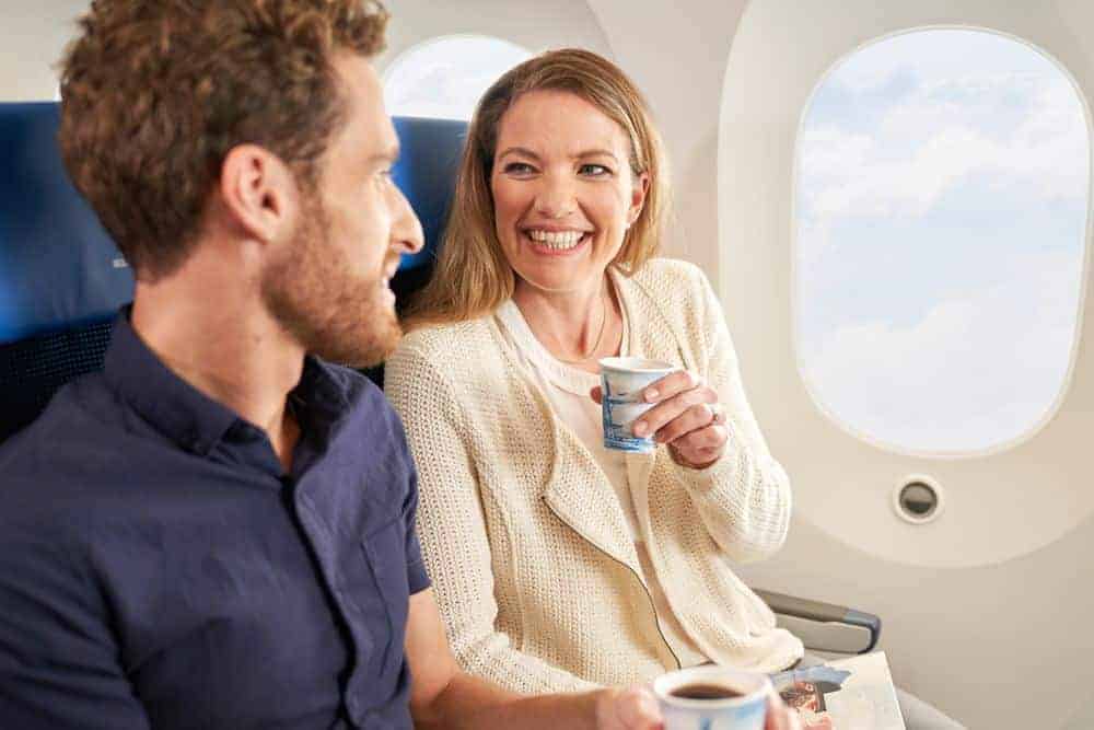 Passagiers in een KLM vliegtuig met koffie