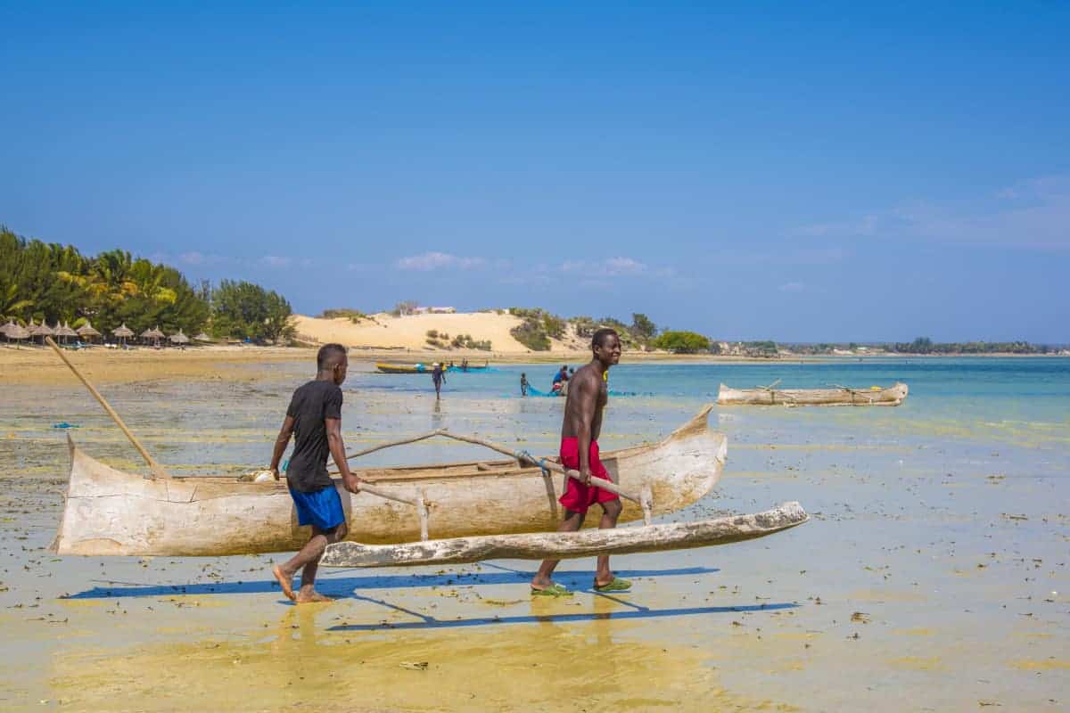 Fotoreis Madagaskar Ifaty mannen dragen vissersboot Fotoreis Madagaskar Ifaty mannen dragen vissersboot