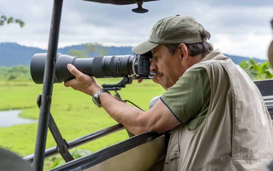 Fotoreis Tanzania Man maakt foto vanuit jeep
