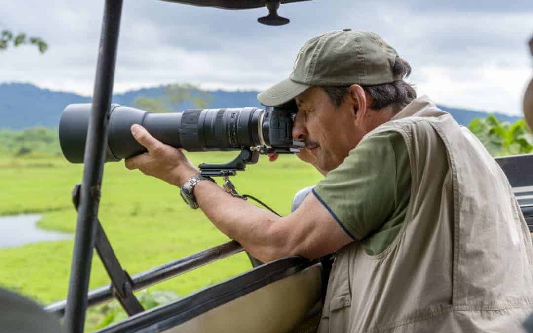 Fotoreis Tanzania Man maakt foto vanuit jeep