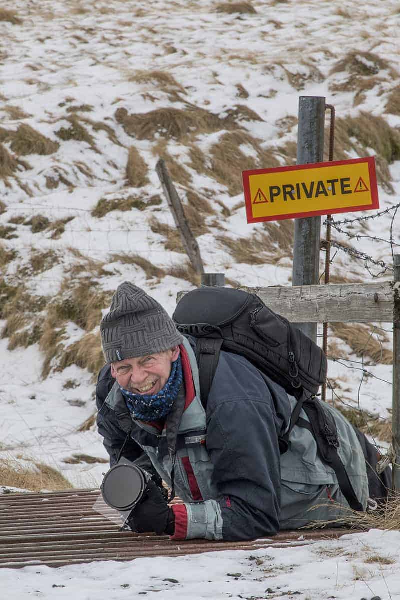 Fotoreizen IJsland Henk kruipt onder hek door bij Fjardarglufur Fotoreizen IJsland Henk kruipt onder hek door bij Fjardarglufur