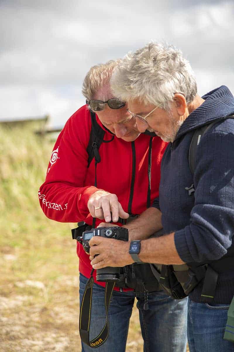 Jan Veijer geeft uitleg aan een deelnemer aan het Fotoweekend Ameland. Jan Veijer geeft uitleg aan een deelnemer aan het Fotoweekend Ameland.