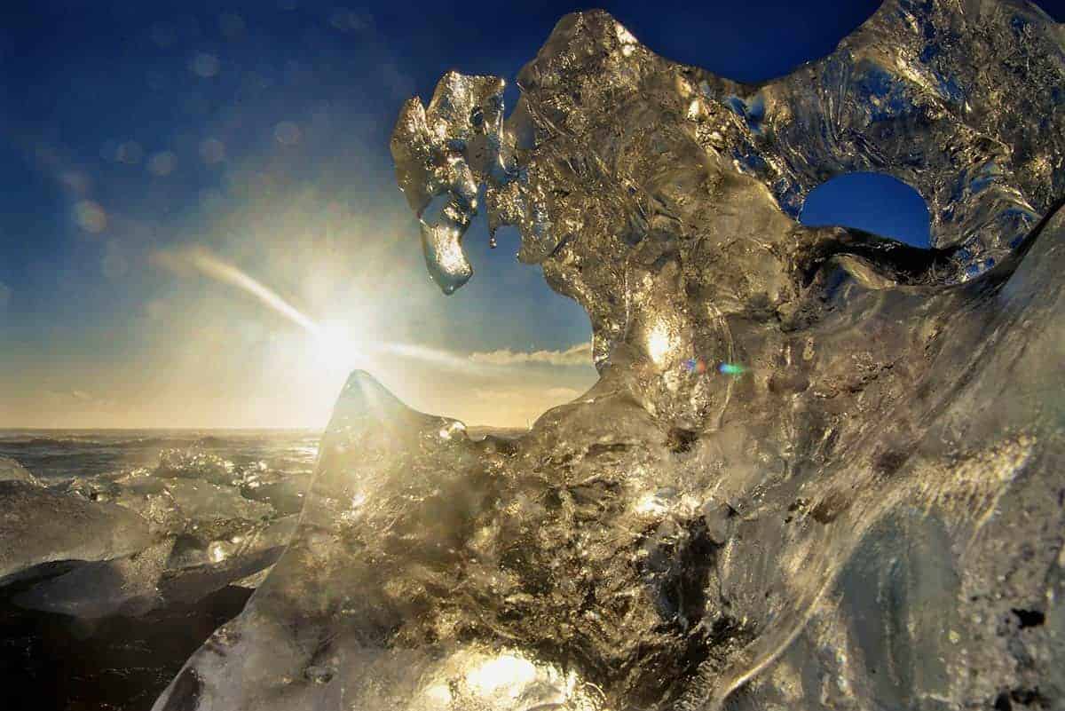 Zon schijnt door een ijsschots in IJsland Zon schijnt door een ijsschots in IJsland